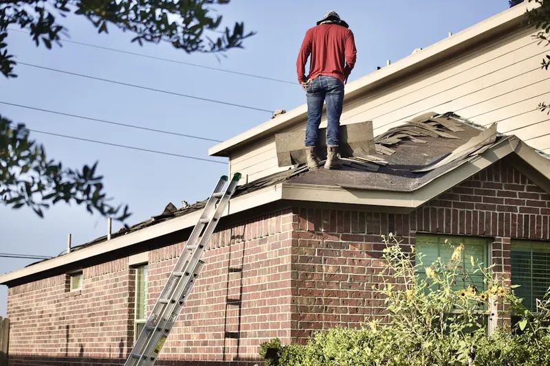 Professional roofer working on a residential roof in Glencove